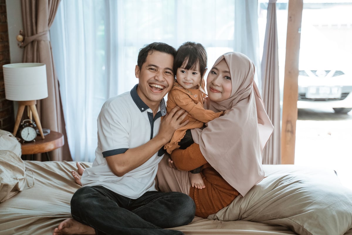 Muslim Families Smile Happily When Hugging While Sitting on the Bed